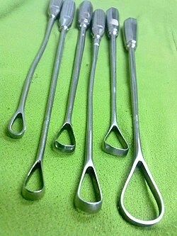 Sada kovových kyretážních nástrojů pro gynekologické zákroky.