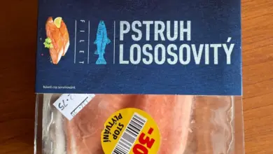 Balancovaný pstruh lososovitý v plastovém obalu na dřevě.