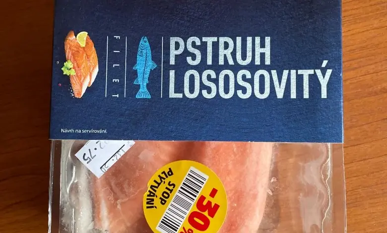 Balancovaný pstruh lososovitý v plastovém obalu na dřevě.