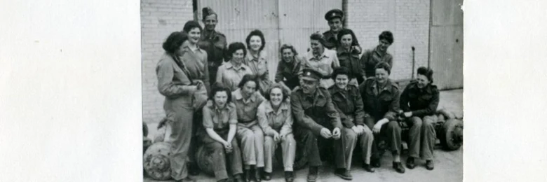 Skupina žen v vojenských uniformách na historické fotografii.