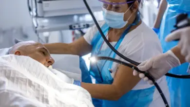 Lékař provádí gastroskopii pacientovi v nemocničním lůžku.