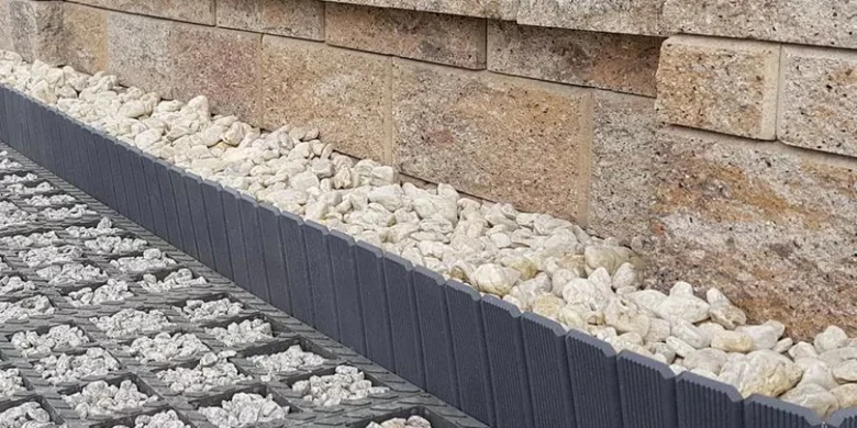 Detail základu opěrné zdi s kamínky pro odvodnění.