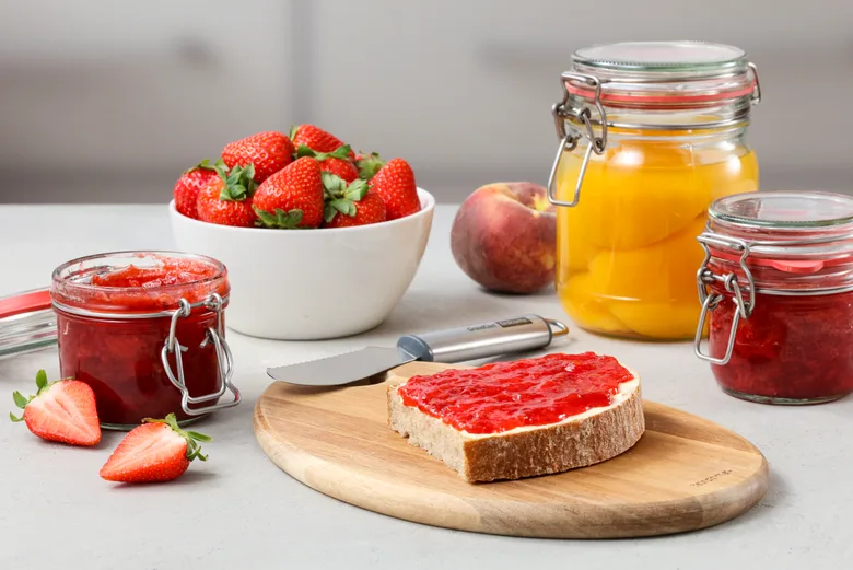 Domácí jahodová marmeláda na toastu s čerstvými jahodami.