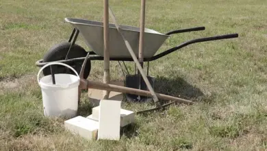 Kolo s kbelíkem a cihly pro stavbu venkovního ohniště.