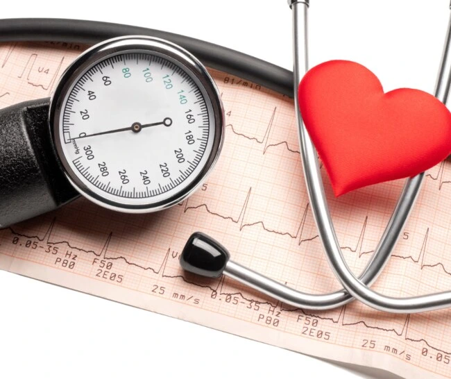 Stetoskop s červeným srdcem na papíru EKG pro měření krevního tlaku.