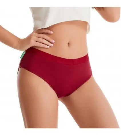 Žena v červených menstruačních kalhotkách na bílém pozadí.