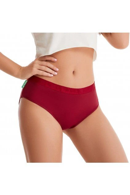 Žena v červených menstruačních kalhotkách na bílém pozadí.