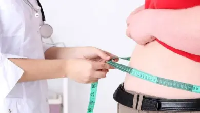 Doctor measuring obese patient waist