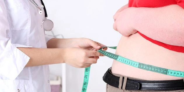 Doctor measuring obese patient waist