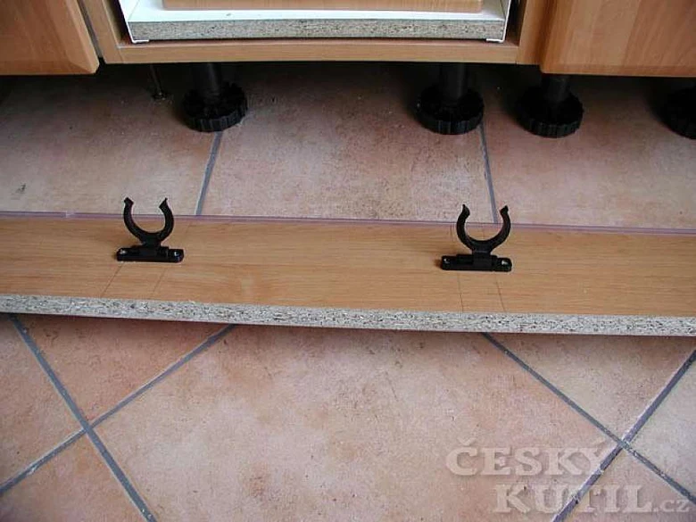 Černé montážní držáky pod dřevěnou desku vestavbové skříně