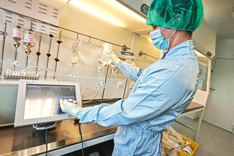 Lékař v čistém prostředí připravuje léky pro nemocné.